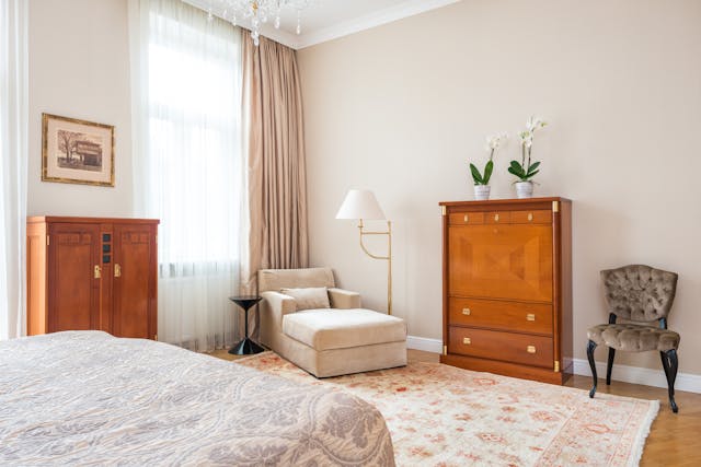 Elegant bedroom with wooden furniture, beige walls, and a patterned area rug.